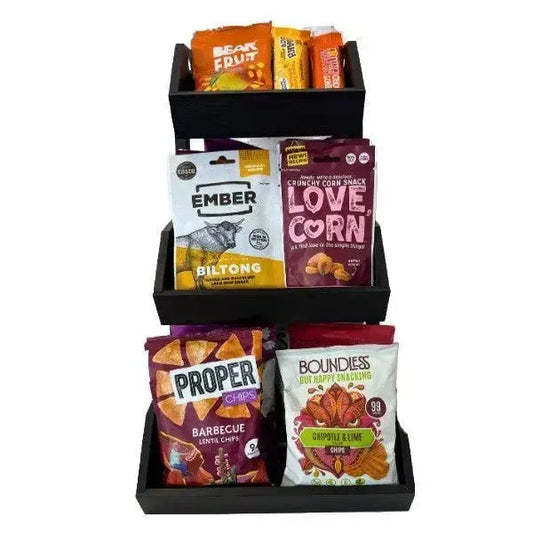 Display of various snack packets in a black holder on a white background