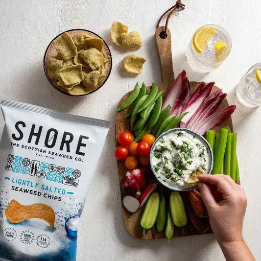 Shore Lightly Salted Seeweed Crisps packs with raw sliced vegetables on a table top