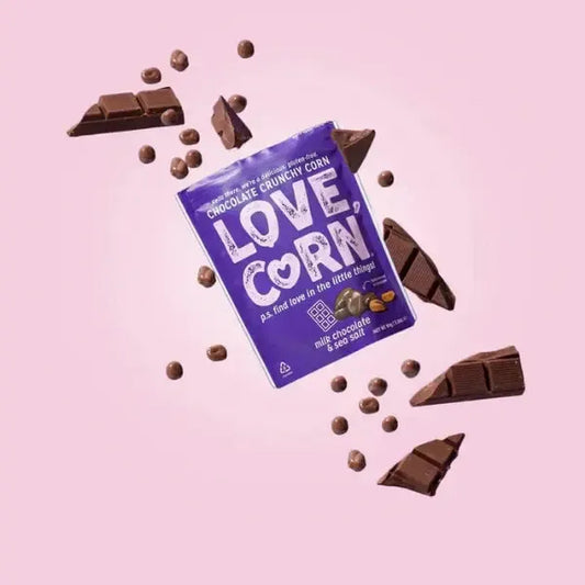 LOVE CORN milk chocolate and sea salt crunchy corn package with chocolate pieces on a pink background