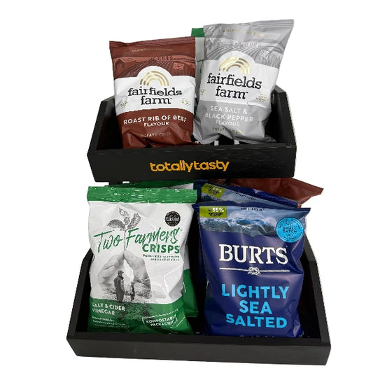 Snack bags from various brands in a black tray on a white surface