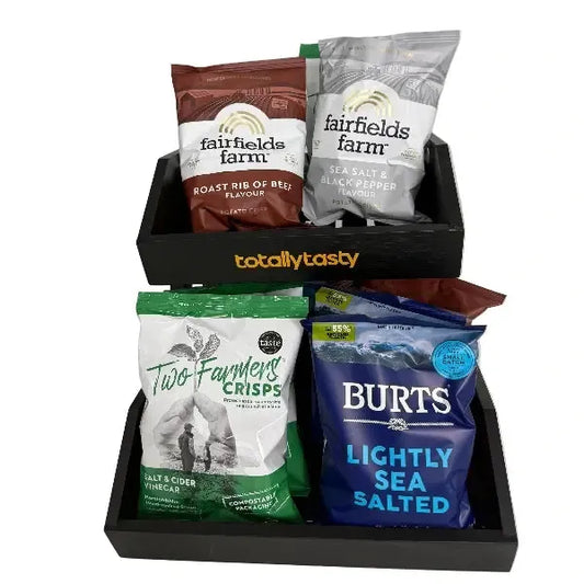 Snack bags from various brands in a black tray on a white surface