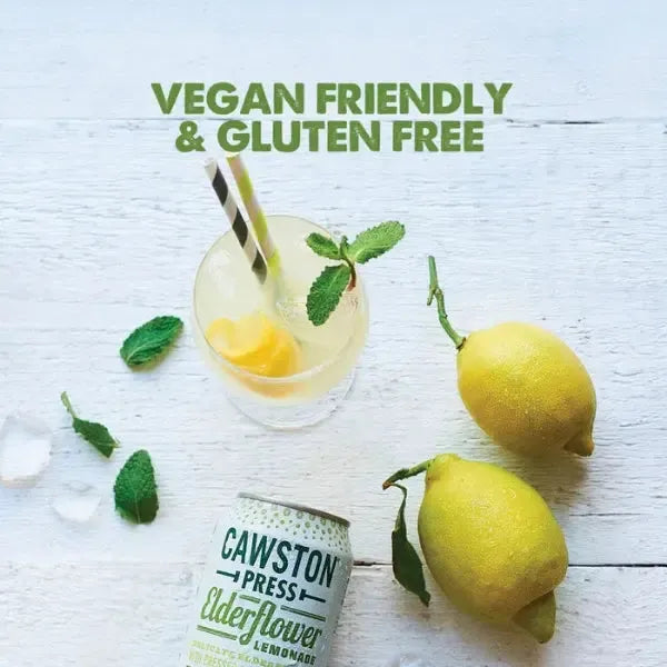 Vegan and gluten-free lemonade with lemons and mint leaves on a white wooden surface.