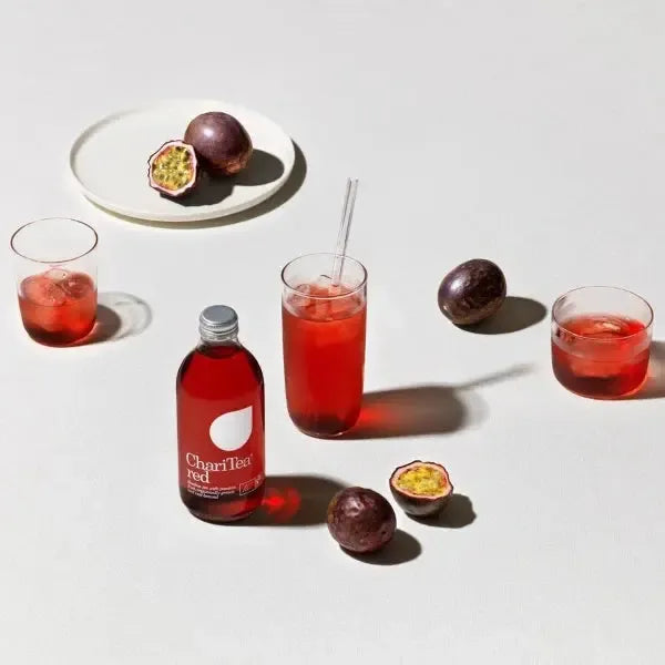 Charitea Red Rooiboos tea with glasses, and passion fruits on a light background