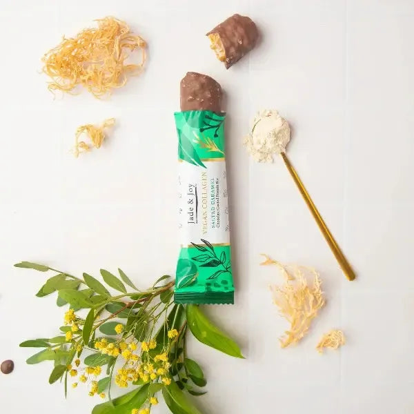 Green-wrapped chocolate bar with a stick, surrounded by decorative elements on a white background