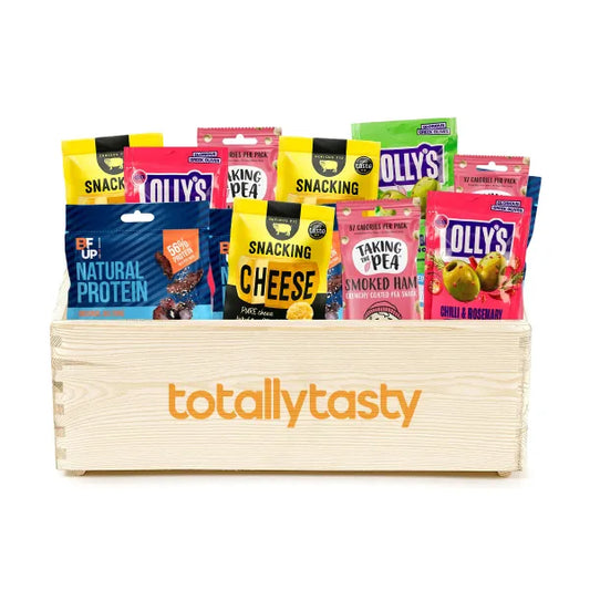 Assorted savoury snack packets in a wooden crate with 'totallytasty' branding.