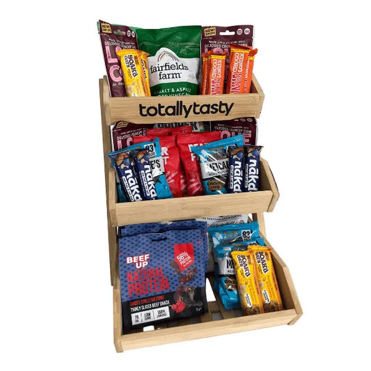 Wooden snack display with various branded packages on a white background