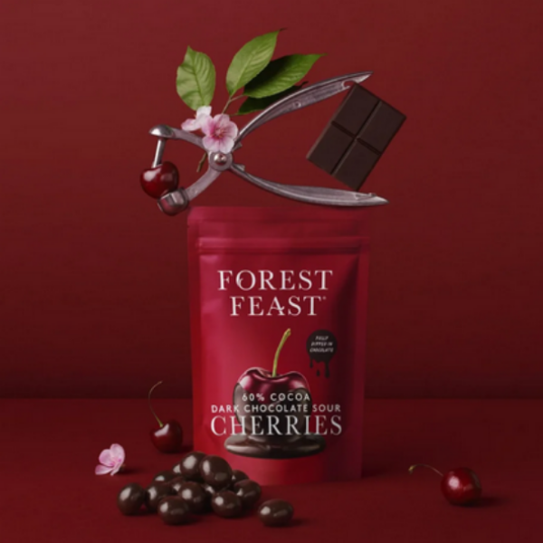 Forest Feast dark chocolate sour cherries packaging with cherries and a chocolate bar on a red background