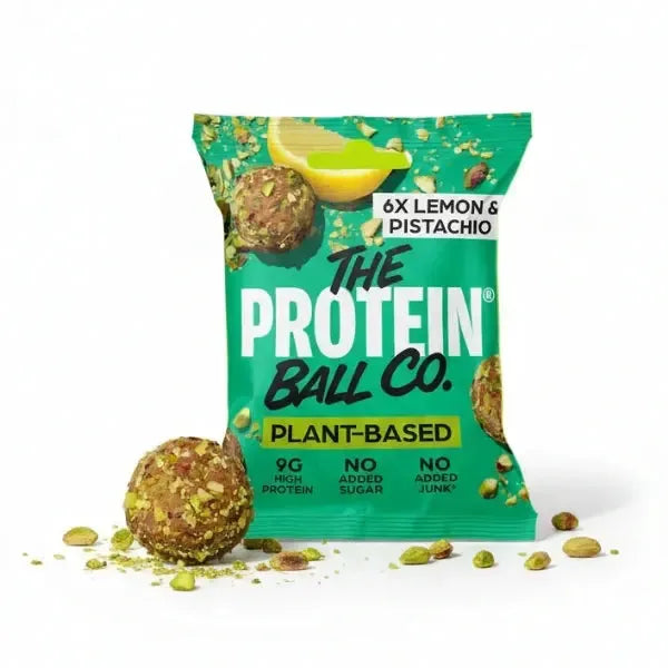 Green packaging of The Protein Ball Co. lemon and pistachio protein balls with a lemon wedge on a white background.